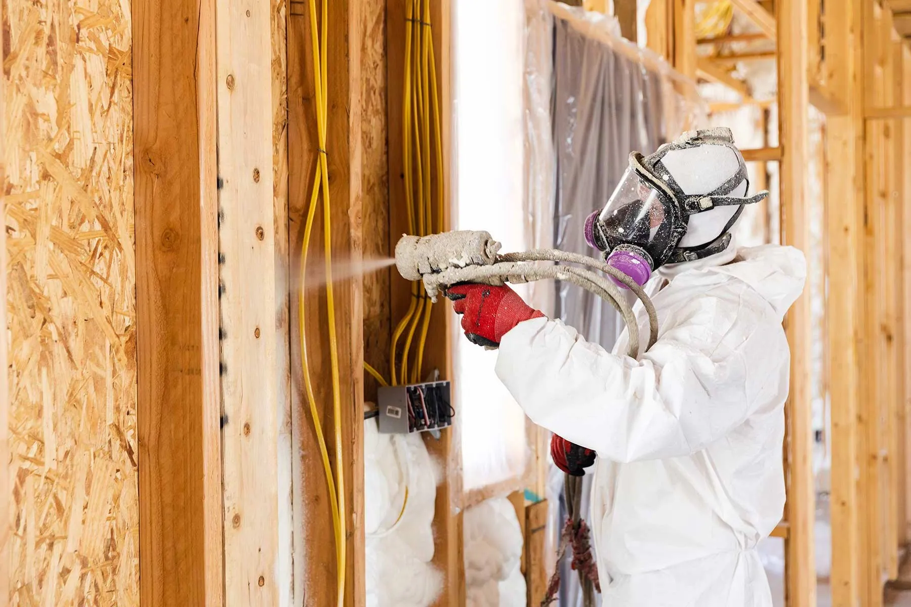 Professional installer applying spray foam insulation in an Arizona building